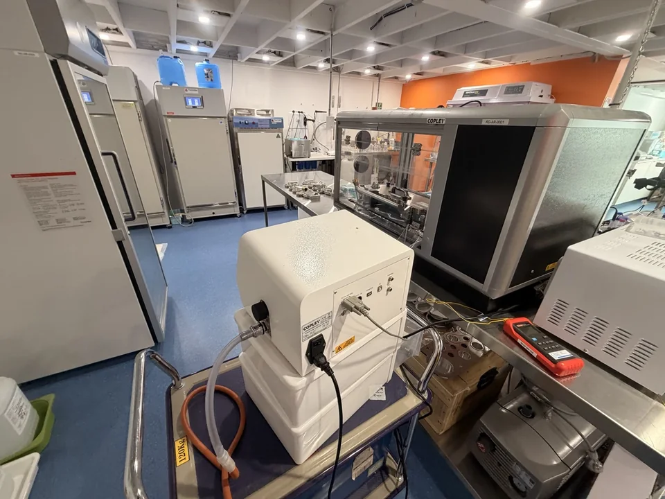 Laboratory overview with tall cabinets, benchtop equipment and a stainless steel work area.