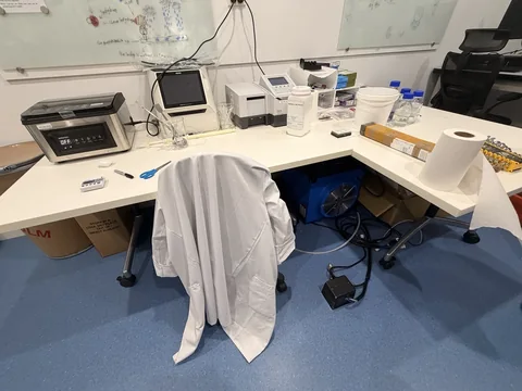 Office workstation with a monitor, chair, benchtop equipment, containers and storage.
