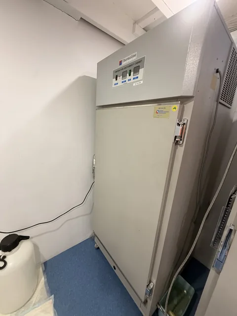 Side view showing the depth, door hardware and surrounding clearance of a tall laboratory cabinet.