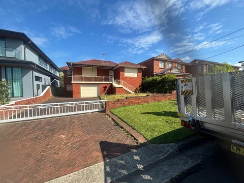 Residential driveway and property entrance beside the truck during the Brisbane sandstone furniture move.