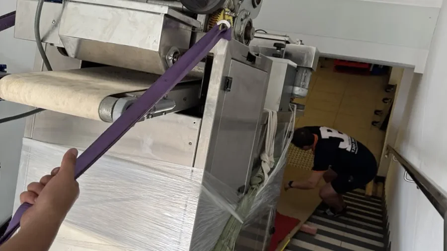 A 500kg commercial machine descending a custom-built stair ramp under controlled restraint in Marrickville
