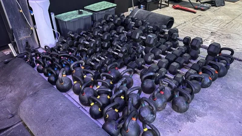 Dumbbells, kettlebells and rolled gym flooring grouped for the Bondi commercial gym relocation