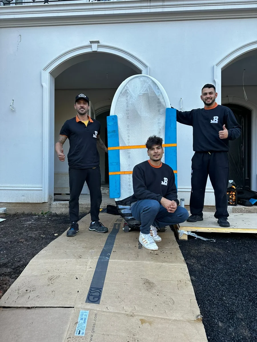 Three JB team members beside the upright protected bath on specialist equipment